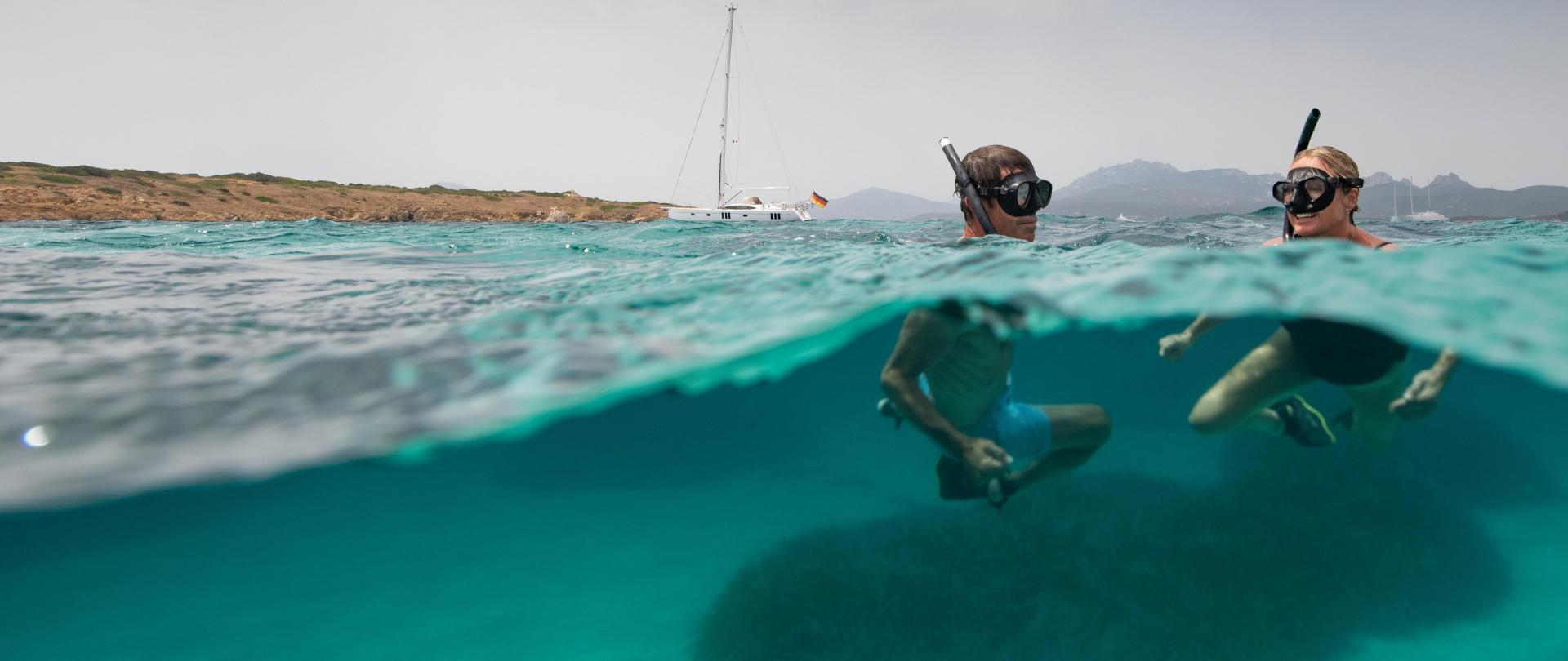man and women snorkelling in Italy.
